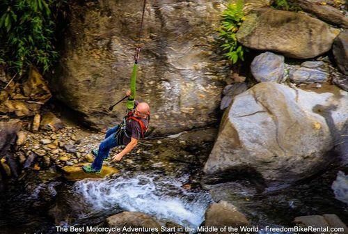 Sylvain on a bridge swing jump near Banos Ecuador on Klim Motorcycle adventure tour