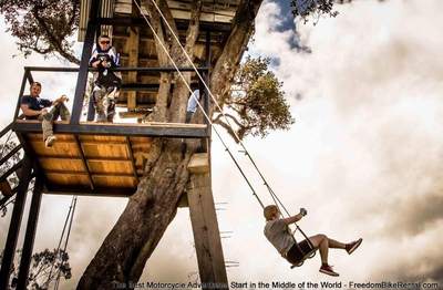 casa del arbol swinging in motorcycle gear banos ecuador