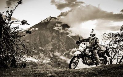 suzuki DR650 with erupting tungurahua volcano in background