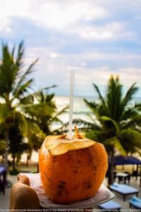 enjoying a coconut on a motorcycle trip to ecuador pacific coast