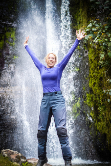 woman motorcyclist with waterfall in the background